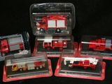quatre camions de pompiers rouges et blancs dans des boîtes en plastique