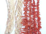 trois colliers de corail et de perles sur un fond blanc
