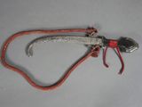 a small metal object with a red cord on it