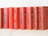 several books are lined up in a row on a white surface