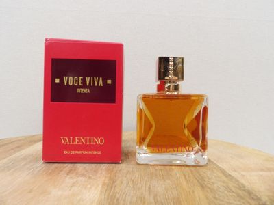 une photo d'un flacon de parfum posé sur une table en bois