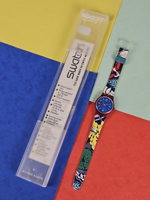 a watch that is sitting next to a package of toothpaste