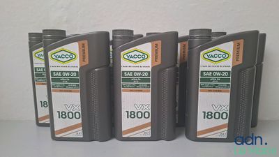 quatre bouteilles d'huile moteur sont alignées sur une table