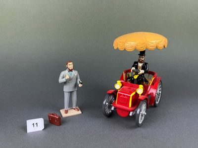 une figurine représentant un homme dans une voiture sur le toit de laquelle est posé un parapluie