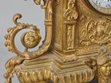 a gold clock that is sitting on top of a table