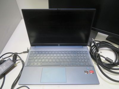 un ordinateur portable posé sur un bureau à côté d'un moniteur