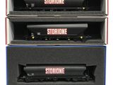 three black and red train cars are stacked in a box