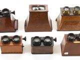 six modèles différents de téléphones anciens exposés sur un support blanc
