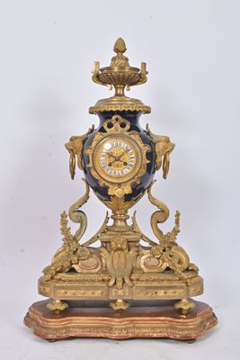 a clock that is sitting on a stand on a white surface