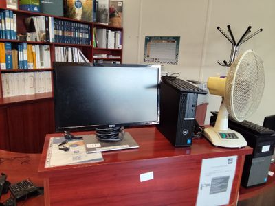 un bureau sur lequel se trouvent un ordinateur et un ventilateur