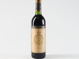 the bottle of wine is sitting on a white surface