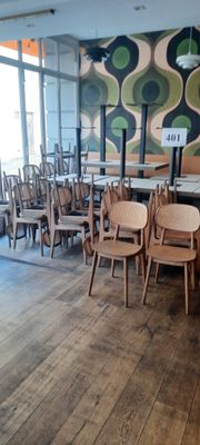 des tables et des chaises dans un restaurant, avec une grande fresque murale en arrière-plan