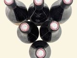 several bottles of wine are arranged in a triangle on a white background