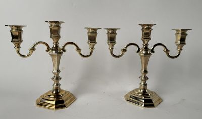 pair of silver plated candlesticks on stands on a white background