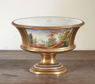 un plateau en or orné d'une peinture, posé sur une table