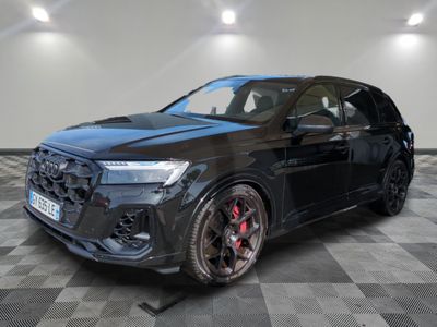 a black audi suv parked on a checkered floor in a showroom