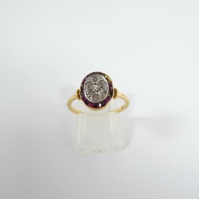 gros plan d'une bague en diamant et rubis sur une surface blanche
