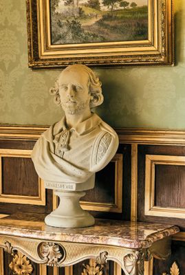 un buste d'homme posé sur une table devant un tableau