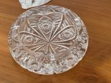 un saladier en verre posé sur une table en bois, à côté d'une serviette en papier