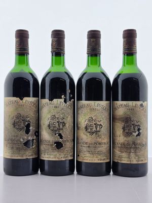 quatre bouteilles de vin sont alignées sur une table