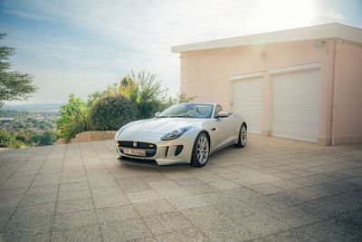 une voiture de sport blanche garée devant un garage