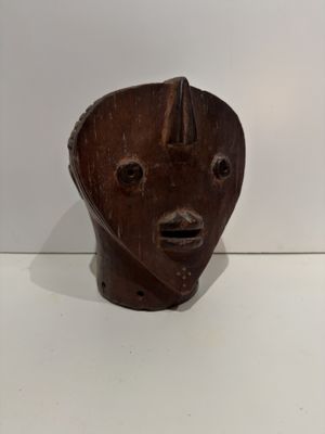 wooden sculpture of a man ' s face on a white surface