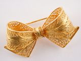 broche en forme de nœud en or, ornée d'un motif en filigrane
