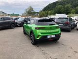 many cars parked in a parking lot with mountains in the background