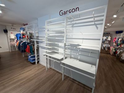 un magasin avec de nombreuses étagères et des vêtements exposés