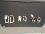 quatre paires de boucles d'oreilles exposées dans une vitrine