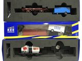 deux boîtes contenant des petits trains miniatures, posées sur une surface blanche