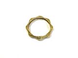 gros plan d'une bague en or sur une surface blanche