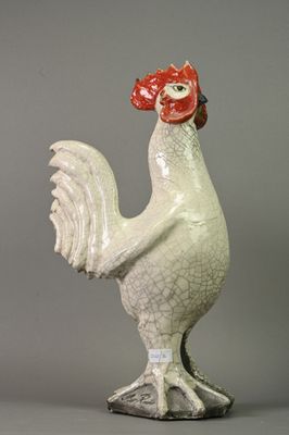 une statue de coq blanc coiffée d'un chapeau rouge