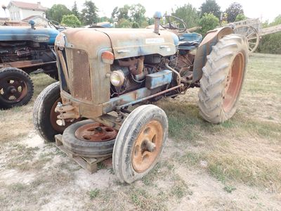 un vieux tracteur qui est à l'abandon dans l'herbe