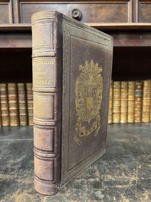an old book sitting on top of a table next to a shelf
