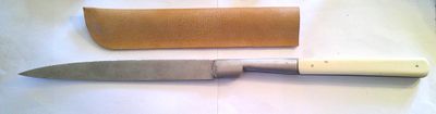 a knife that is laying next to a piece of paper