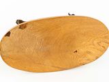 a wooden oval shaped object on a white surface