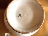 a white bowl sitting on a table with a brown table cloth