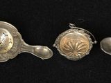 five spoons and a spoon rest in a row on a black surface
