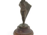 statue of a woman holding a umbrella on a wooden base