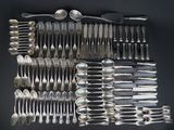 a lot of spoons and forks arranged together on a table