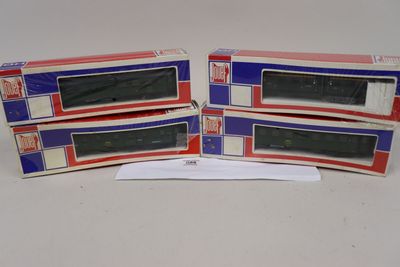 trois cartons contenant des trains miniatures posés sur une table blanche
