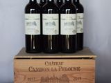 quatre bouteilles de vin se trouvent dans une caisse en bois posée sur une table