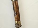 a wooden stick with a metal handle on a white surface