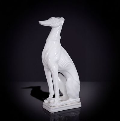 statue d'un lévrier blanc assis sur une surface noire