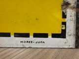 a close up of a yellow and black sign on a wooden floor