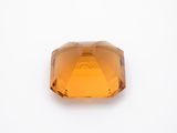 a close up view of a faceted orange sapphire stone