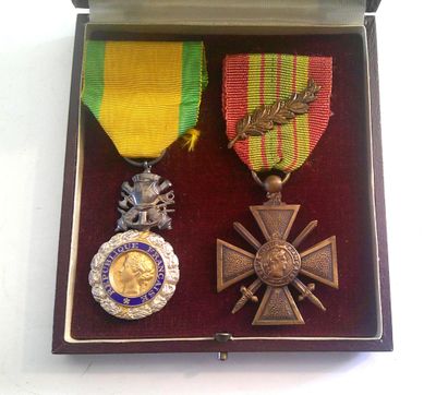 two medals and a medal in a wooden box