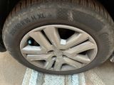 a cat that is sitting on the tire of a car