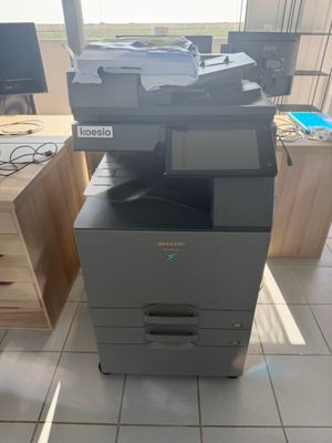 a photo of a multi - function printer sitting on top of a desk